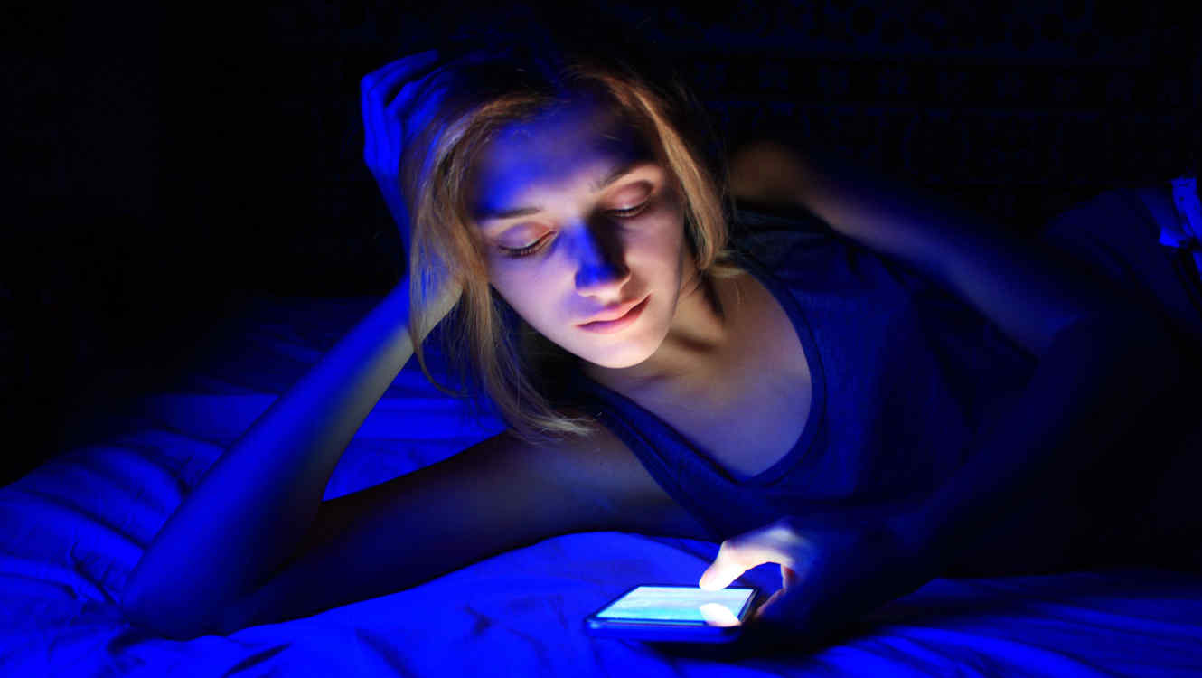 Luz azul mujer recostada viendo celular